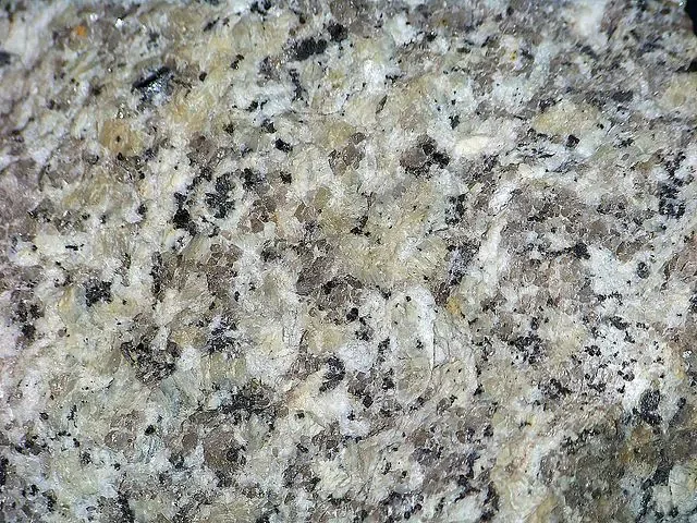 Textura de granito claro com pontos escuros, material trabalhado pela marmoaria em Cascavel